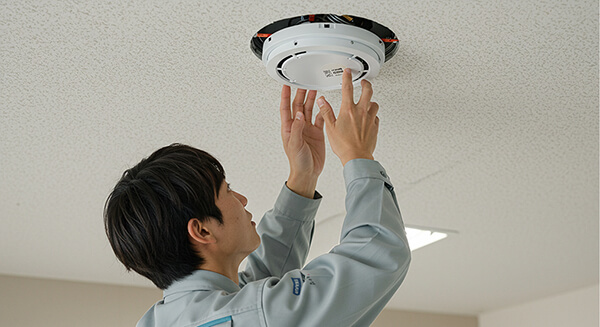 火災報知器を設置する作業員